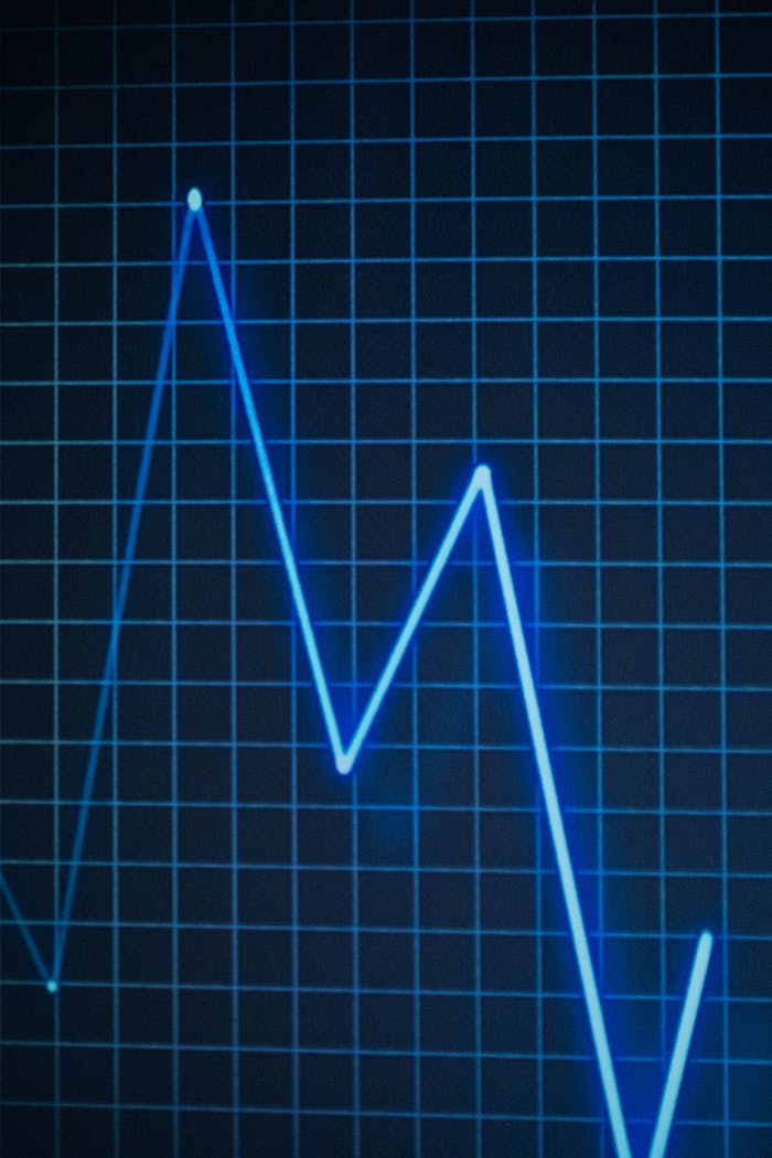 Close-up of a neon blue line chart on a grid, symbolizing data trends.